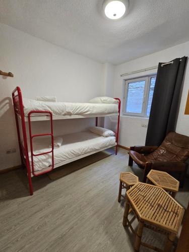 Zimmer mit 2 Etagenbetten und einem Stuhl in der Unterkunft Agradable apartamento familiar in Sierra Nevada