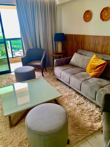 a living room with a couch and a table at INOVA FLAT conforto no Condominio Cosmopolitan in Palmas