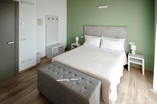 a bedroom with a large bed and a tufted couch at La Casina di Ely B&B in SantʼAndrea in Casale
