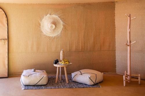 a room with three ottomans and a table in a room at Celia Desert Camp in Merzouga