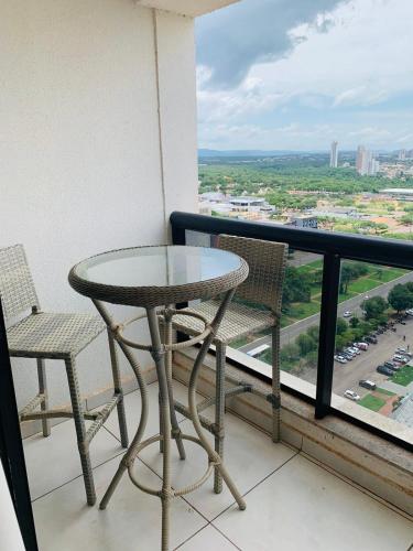 a table and chairs on a balcony with a view at INOVA FLAT conforto no Condominio Cosmopolitan in Palmas