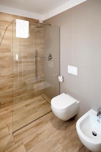 a bathroom with a shower and a toilet and a sink at La Casina di Ely B&B in SantʼAndrea in Casale
