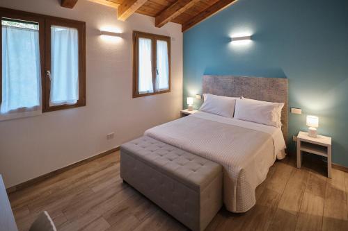 1 dormitorio con 1 cama grande y 2 ventanas en La Casina di Ely B&B, en SantʼAndrea in Casale