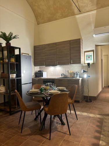 een keuken met een tafel en stoelen en een koelkast bij Appartamento L'antica colonna, in centro storico in Parma