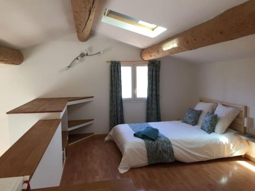 a bedroom with a bed and a desk in it at Jolie maison de ville au calme in Châteauneuf-lès-Martigues