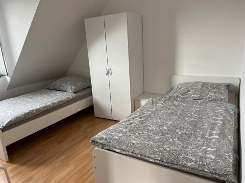 um pequeno quarto com 2 camas e um armário em Messezimmer nahe Flughafen direkte Verbindung Messe em Langenhagen