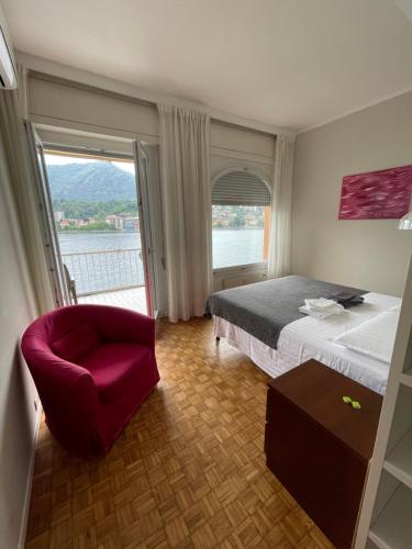 a bedroom with a bed and a chair and a window at CASA DEL LAGO in Omegna