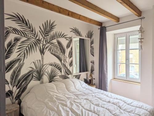 1 dormitorio con un mural de palmeras en la pared en Maison de ville à 5mn de la plage-jardin clos proche plage en Planguenoual