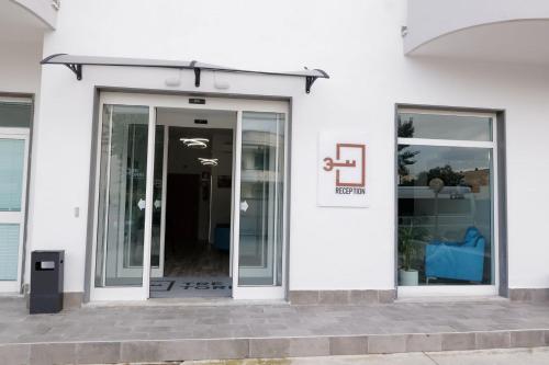 a white building with a sliding glass door at Albergo 3 Torri in Maddaloni