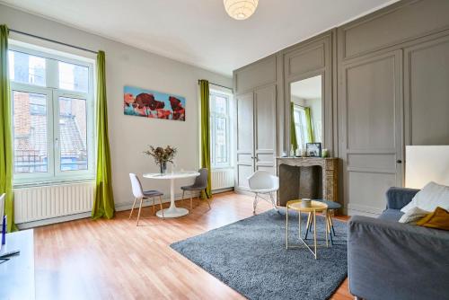 salon z kanapą i stołem w obiekcie Charmant appartement central w Lille