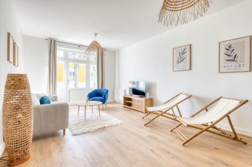 una sala de estar con un sofá y una silla en Appartement Aigrette - La Maison Heureuse - Welkeys, en Saint-Georges-dʼOléron