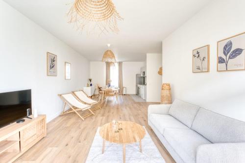 un salon avec un canapé et une table dans l'établissement Appartement Aigrette - La Maison Heureuse - Welkeys, à Saint-Georges-dʼOléron
