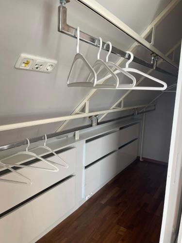a kitchen with white drawers and hangers at InselSuites FinkenNest Airbus Finkenkwerder 125 m2 Kamin in Hamburg