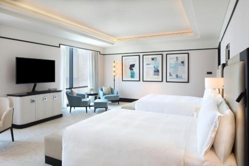 a hotel room with a bed and a television at Waldorf Astoria Doha West Bay in Doha