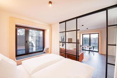 a bedroom with a white bed and a large window at Mono Design Apartments in Stuttgart