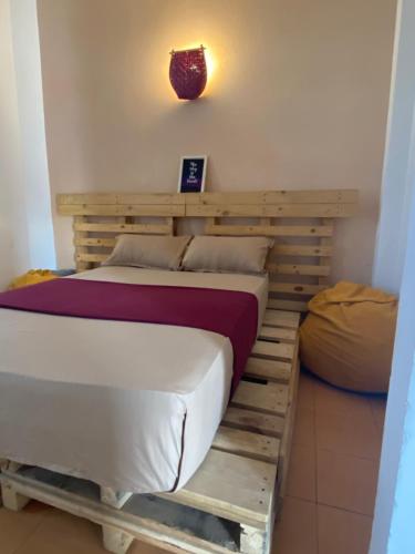 a bed in a room with a wooden bed frame at Seconds Hostel - Colombo in Colombo