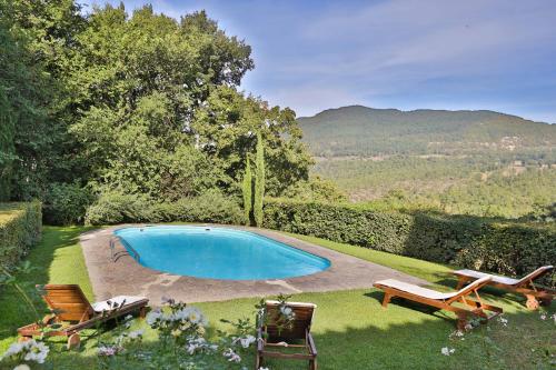 een zwembad in een tuin met twee stoelen bij Villa Casanova in Cerbaiolo