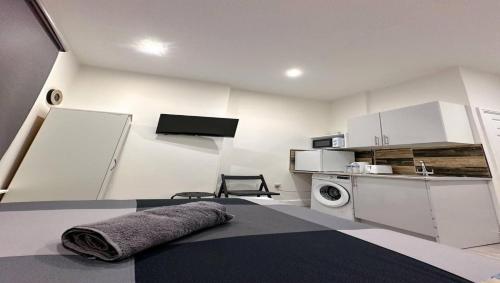 Biały pokój z kuchnią i pralką w obiekcie Studio flat in Ealing Broadway w Londynie