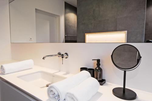 bagno con lavandino e specchio di Mono Design Apartments a Stoccarda