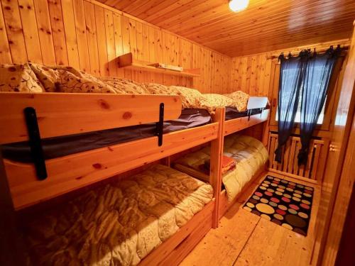 a bedroom with two bunk beds in a cabin at Tormentina - Piancavallo in Piancavallo