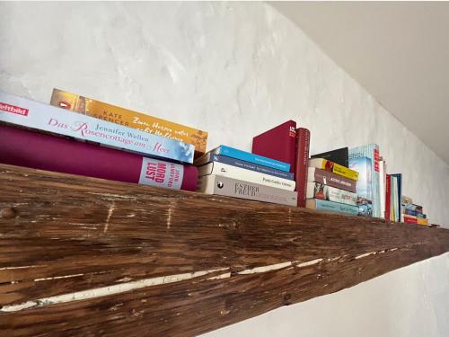 a pile of books sitting on top of a shelf at Alte Bäckerei Gnade auf Rügen in Sehlen