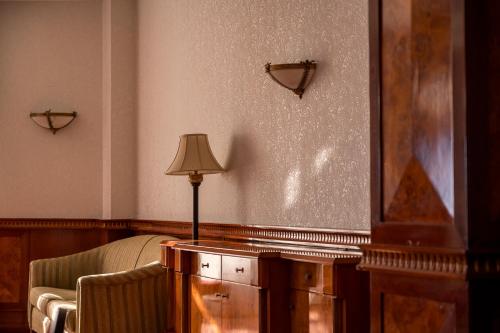 a room with a bed and a lamp and a chair at Hotel Golden Palace in Göd