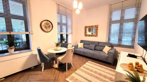 a living room with a couch and a table at APARTAMENT JARACZA 28/9 in Słupsk