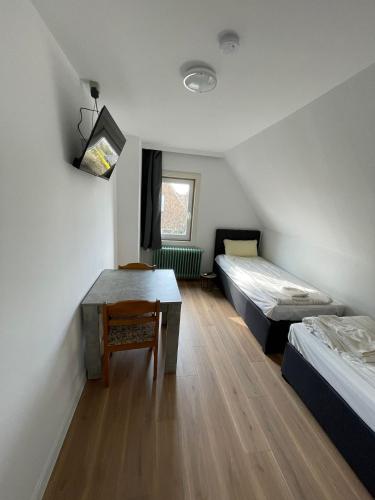 a room with two beds and a table in it at Ruhige Unterkunft im Norden von Neumünster in Neumünster