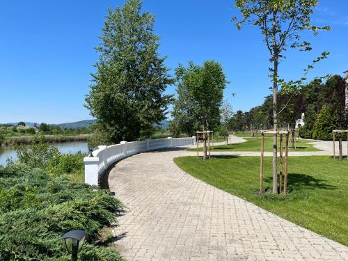 een loopbrug in een park naast een rivier bij Hotel Golden Palace in Göd