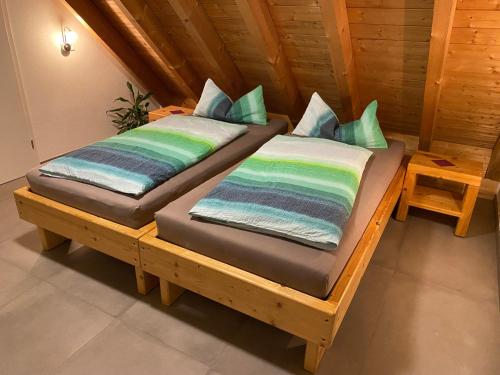 two beds sitting on a wooden bench in a room at Ferienbauernhof-Holops in Sankt Georgen im Schwarzwald