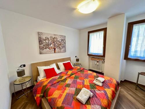 um quarto com uma cama grande e um cobertor colorido em Panoramica terrazza sulle piste sciistiche em Gressoney-Saint-Jean