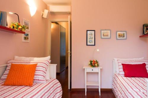 a bedroom with two beds and a table with a mirror at Villa Ametista in Meina