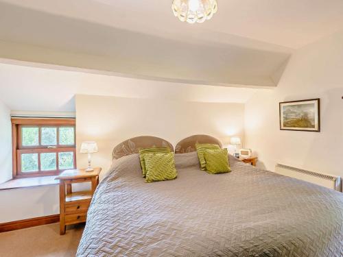 a bedroom with a large bed with green pillows at 1 Bed in Crosthwaite LCC70 in Crosthwaite