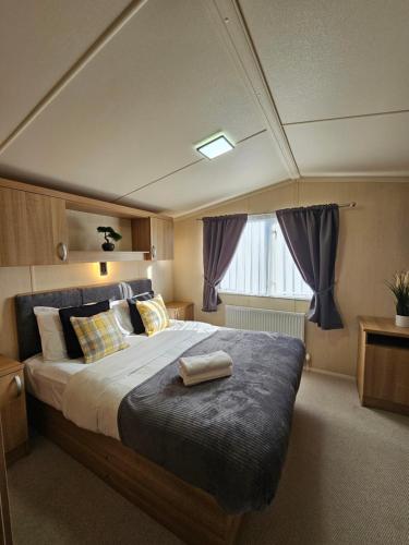 a bedroom with a large bed with purple curtains at Beautiful caravan near Edinburgh nr 14 in Port Seton