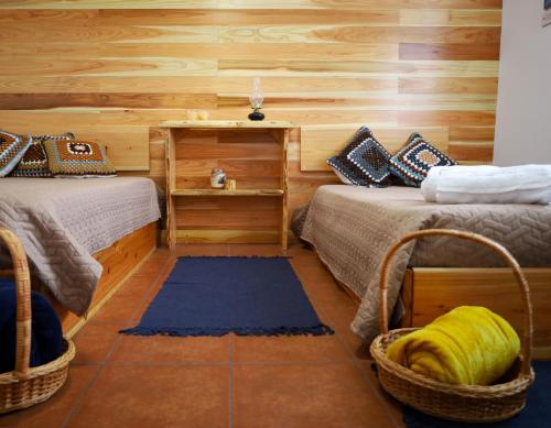 two beds in a room with wooden walls at Beleza da Fazenda in Nordeste