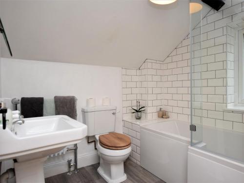 a white bathroom with a toilet and a sink at 1 Bed in Great Torrington ANNAS in Langtree