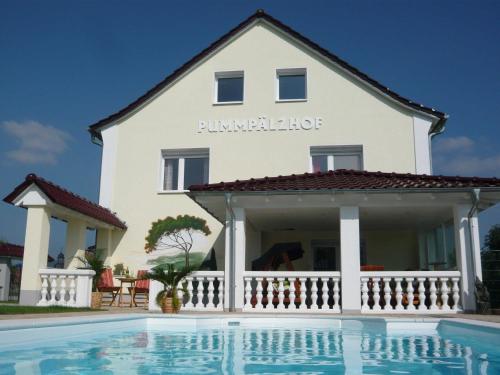 a villa with a swimming pool in front of a house at Pummpälzhof in Bad Salzungen