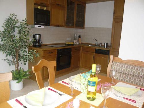 a kitchen with a table with a bottle of wine at Pummpälzhof in Bad Salzungen