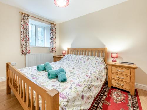 a bedroom with a bed with two blue pillows on it at 2 Bed in Barnstaple MOOSC in Chapelton