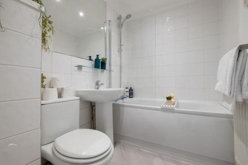 ein weißes Bad mit einem WC und einem Waschbecken in der Unterkunft Bright bold beautiful Close to Brighton station in Brighton & Hove