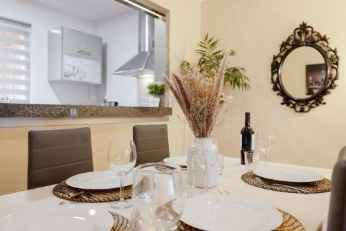 a dining room table with glasses and a mirror at Los Cármenes in Algeciras