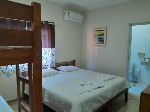 a bedroom with a bed and a bunk bed at Residencial Águas de Bare in São Sebastião