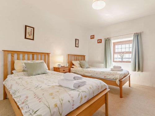 1 dormitorio con 2 camas y ventana en 3 Bed in Falmouth CONWI, en Constantine