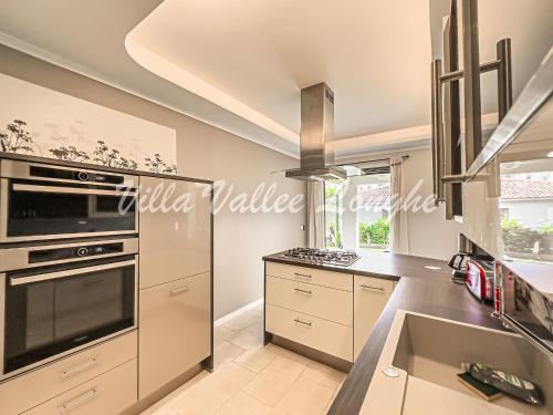 Il comprend une cuisine équipée d'une cuisinière. four supérieur à côté d'un évier dans l'établissement Villa Talasani, à Talasani