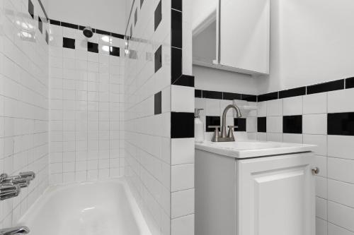 een witte badkamer met een wastafel en een bad bij 89-3FS Newly Furnished 2br 1bath UES in New York