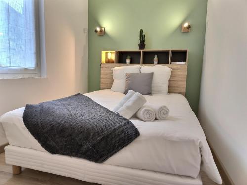 une chambre avec un grand lit blanc avec des serviettes dessus dans l'établissement Le Pastelier - Parking privé - Clim, à Albi