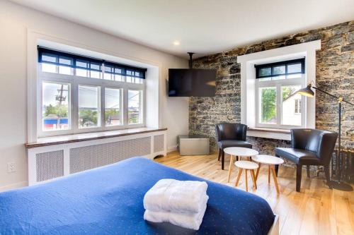 um quarto com uma cama azul e uma sala de estar em Maison Grenier - Le Loft em Cidade de Quebec