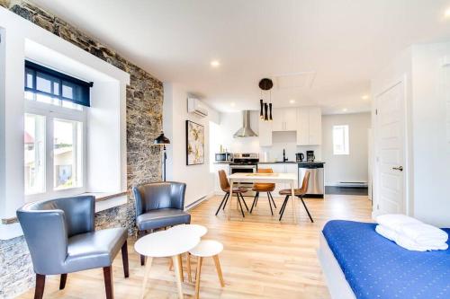 a living room with a bed and a table and chairs at Maison Grenier - Le Loft in Quebec City