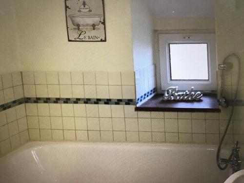 La salle de bains est pourvue d'une baignoire et d'une fenêtre. dans l'établissement Holiday Cottage Cornwall, à Delabole