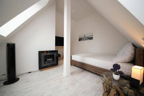 um quarto branco com uma cama e uma lareira em Sealect-Hus-4-Timmendorfer-Strand-mit-Sauna em Timmendorfer Strand